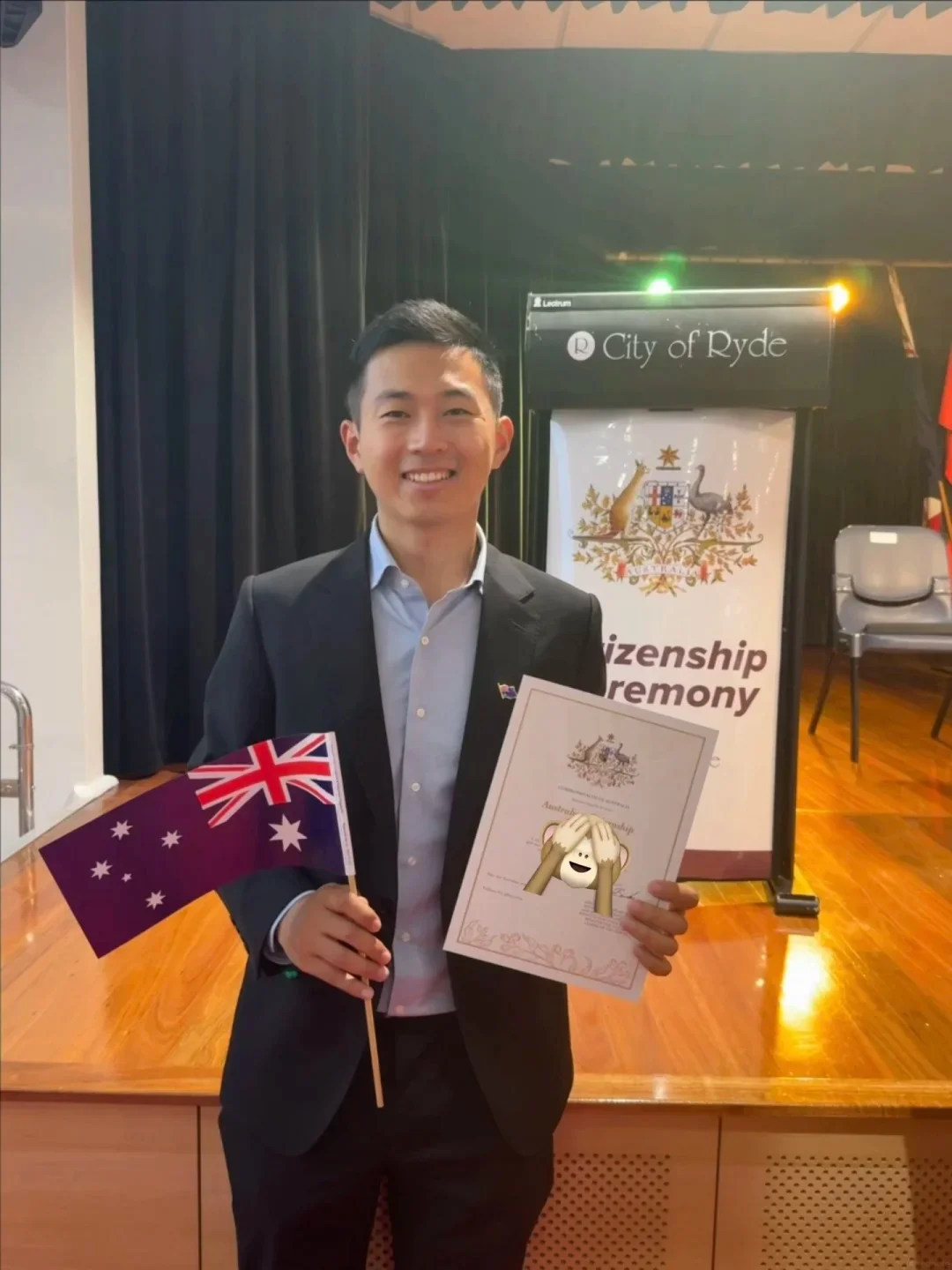 Man holding Australian citizenship certificate with flag